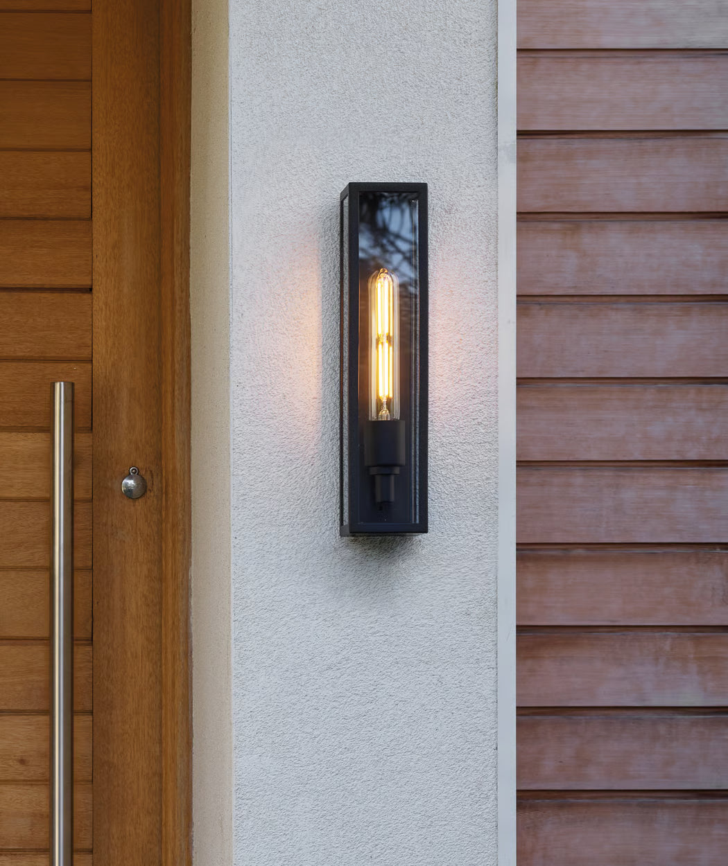 Modern Astro exterior wall light illuminating a residential entrance, suitable for patios, hotels, hospitality venues and commercial properties.